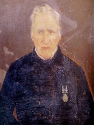 William Owston posando con la Medalla por Servicios Generales en la Marina con distintivo de San Sebastián.